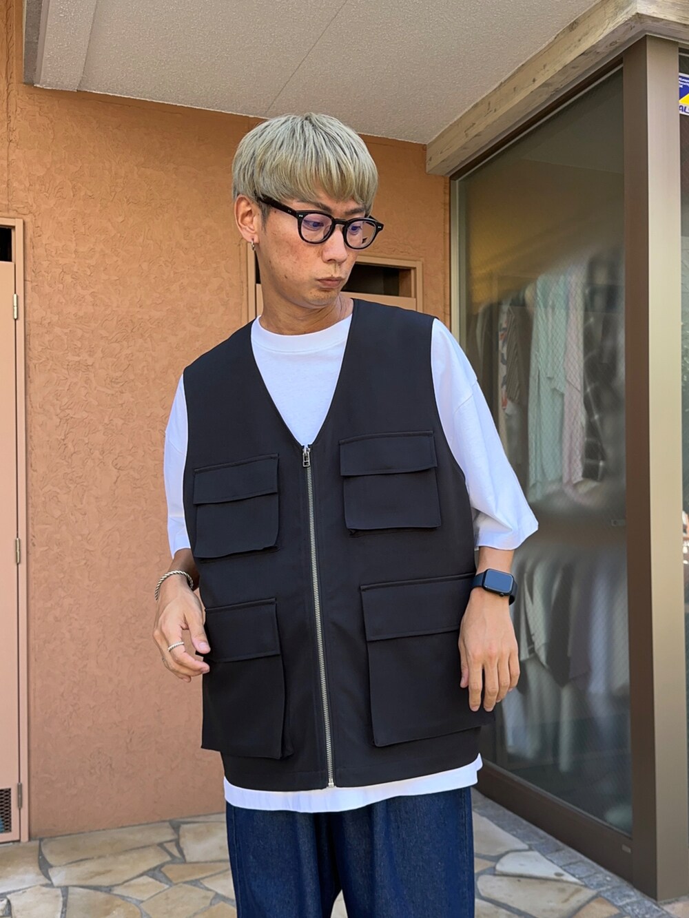 ブラック系のベスト、ブルー系のデニムパンツ、ホワイト系のTシャツ/カットソーを着用したメンズの夏コーディネートの4枚目の写真