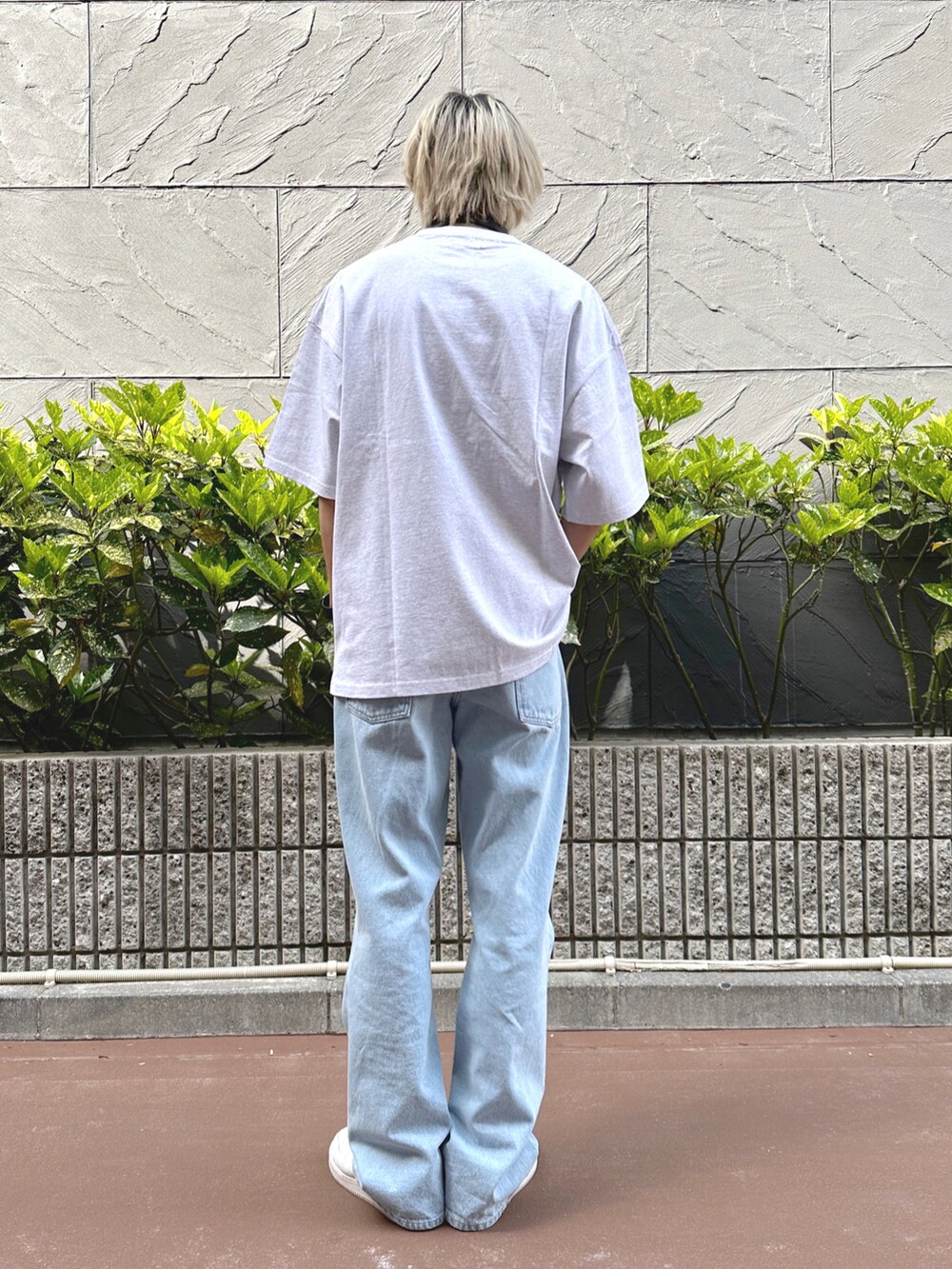 ブルー系のデニムパンツ、ホワイト系のスニーカー、グレー系のTシャツ/カットソーを着用したメンズの春コーディネートの2枚目の写真