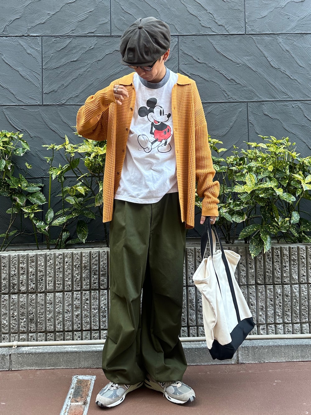 イエロー系のカーディガン/ボレロ、グリーン系のカーゴパンツ、その他のトートバッグを着用したメンズの春コーディネートの2枚目の写真