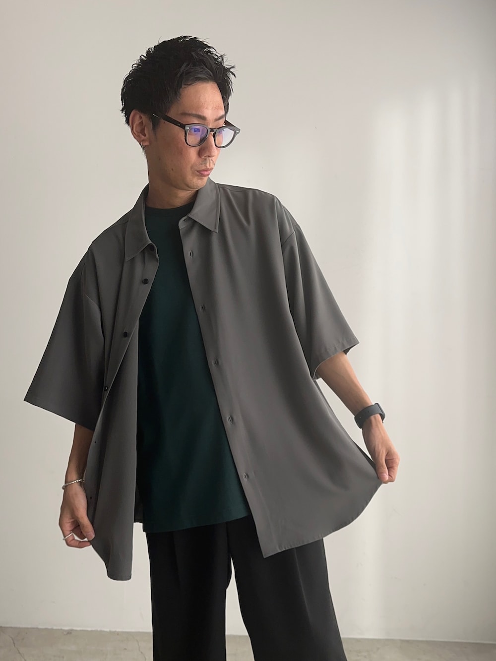 グレー系のシャツ/ブラウス、グリーン系のTシャツ/カットソー、ブラック系のスラックスを着用したメンズの夏コーディネートの4枚目の写真