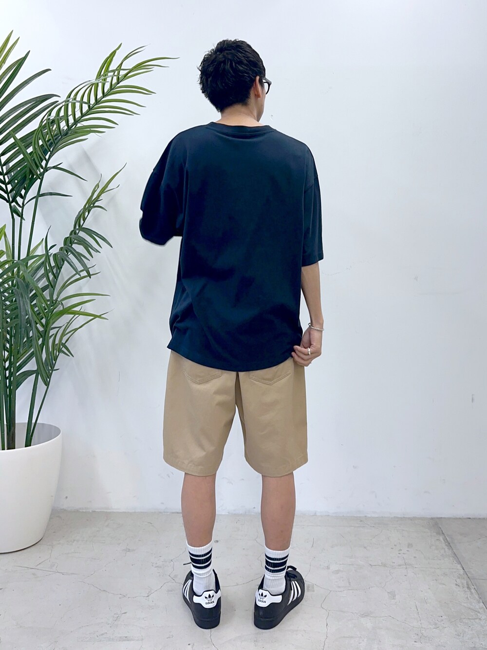 ブルー系のTシャツ/カットソー、ブラック系のスニーカー、ベージュ系のチノパンツを着用したメンズの夏コーディネートの2枚目の写真