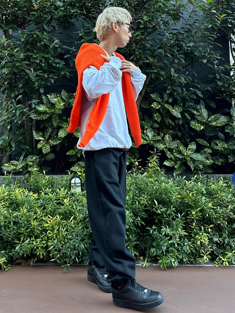 グレー系のスウェット、オレンジ系のカーディガン/ボレロ、ブラック系のスウェットパンツを着用したメンズの冬コーディネートの2枚目の写真