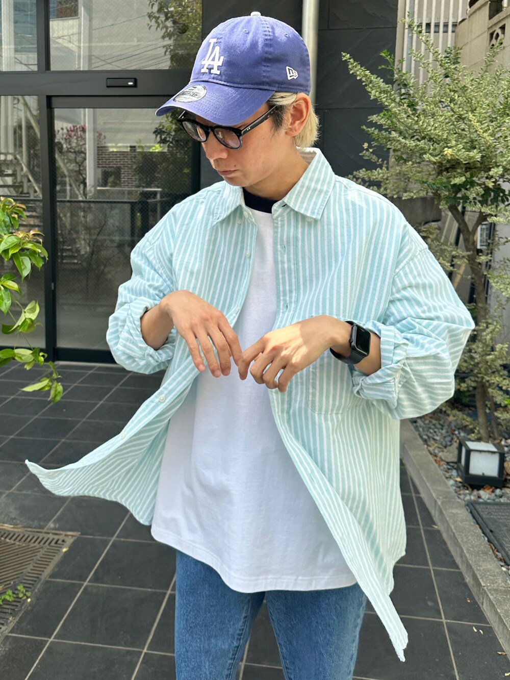 グリーン系のシャツ/ブラウス、その他のTシャツ/カットソー、ブルー系のデニムパンツを着用したメンズの春コーディネートの5枚目の写真