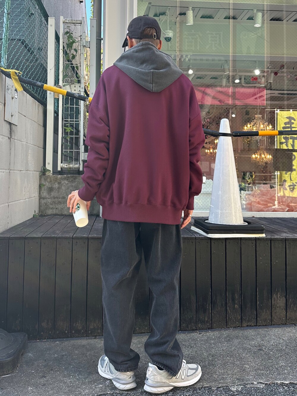 レッド系のスウェット、ブラック系のデニムパンツ、ブラック系のTシャツ/カットソーを着用したメンズの秋コーディネートの2枚目の写真