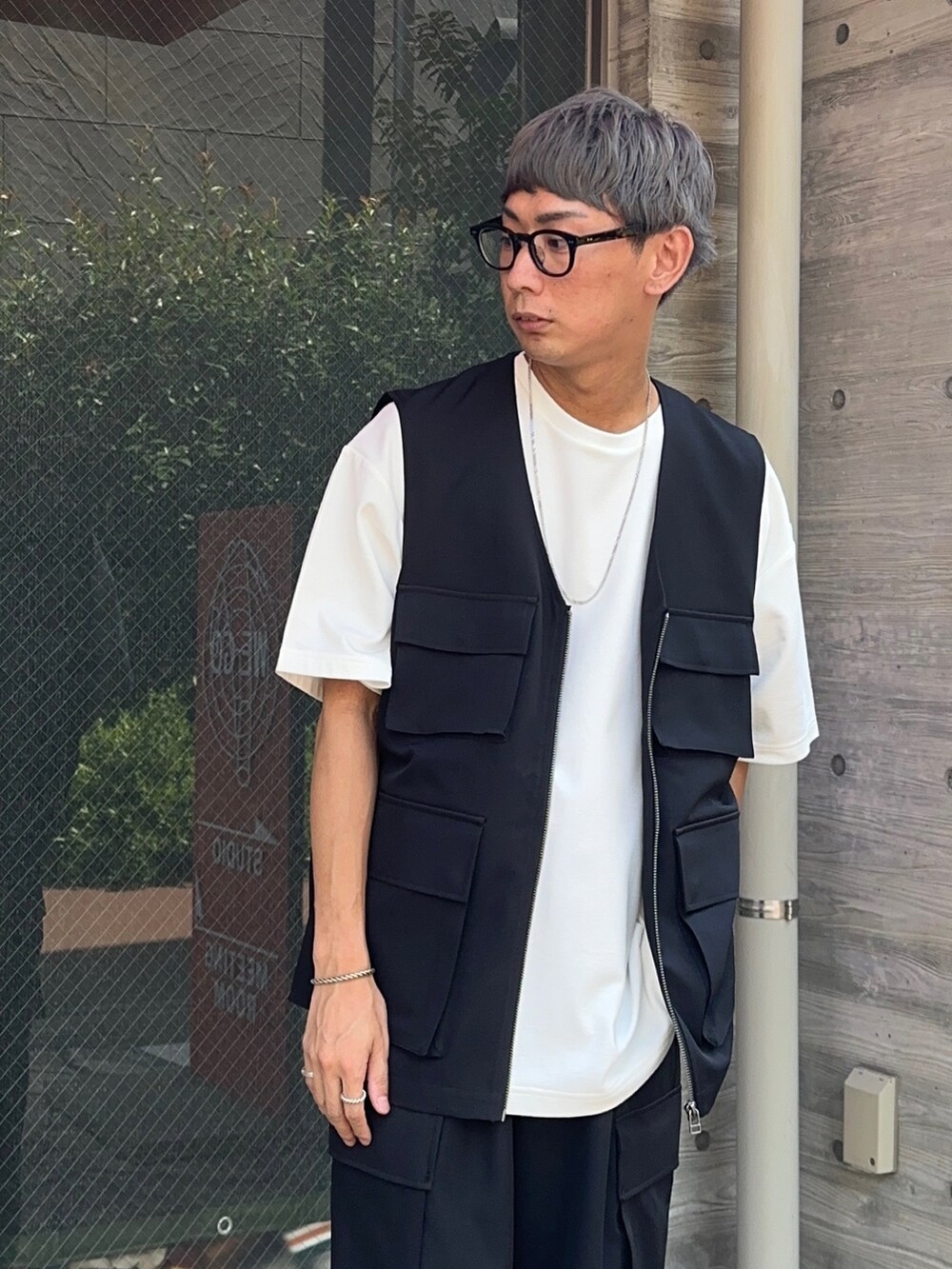 ホワイト系のTシャツ/カットソー、ブラック系のベスト、ブラック系のカーゴパンツを着用したメンズの夏コーディネートの3枚目の写真