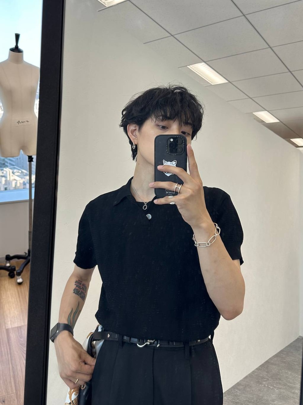 ブラック系のポロシャツ、ブラック系のスラックス、ブラック系のドレスシューズを着用したメンズの夏コーディネートの4枚目の写真