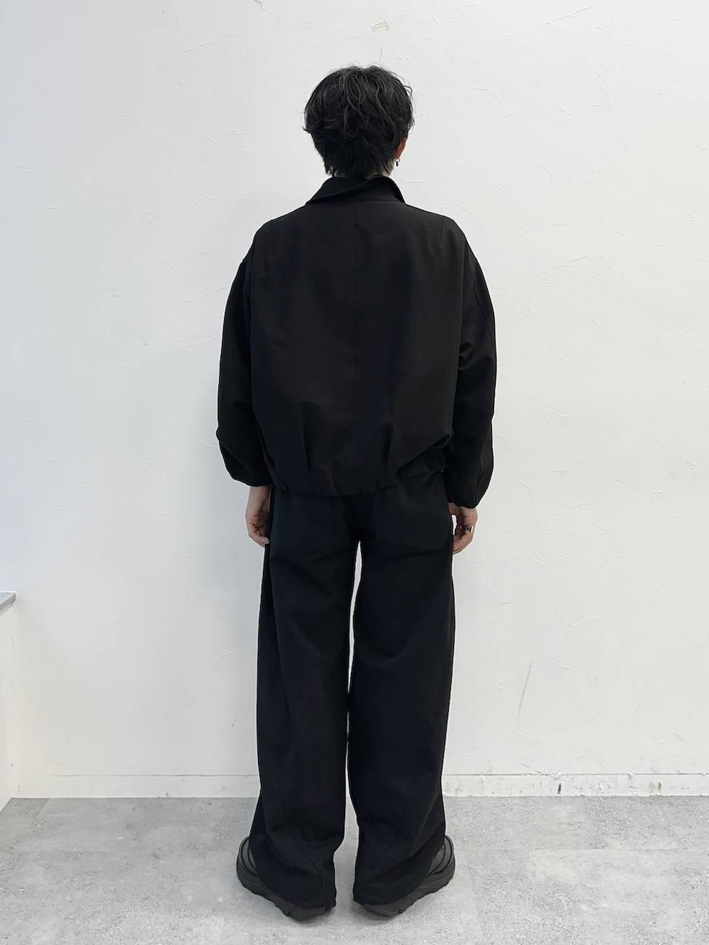 ブラック系のスウェットパンツ、ブラック系のブルゾン、ブラック系のベルトを着用したメンズの秋コーディネートの3枚目の写真