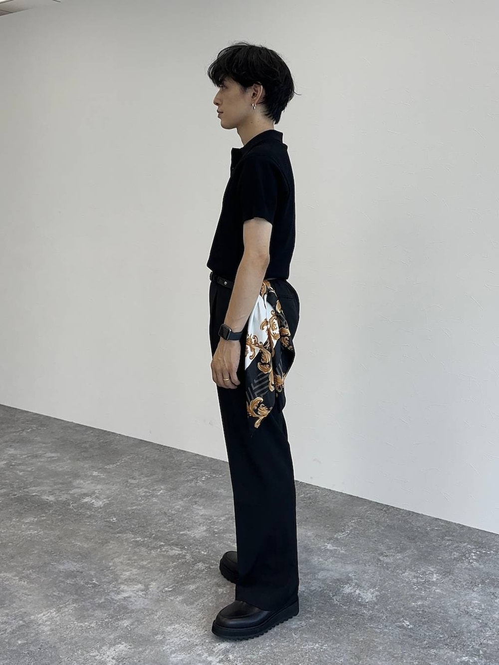 ブラック系のポロシャツ、ブラック系のスラックス、ブラック系のドレスシューズを着用したメンズの夏コーディネートの2枚目の写真