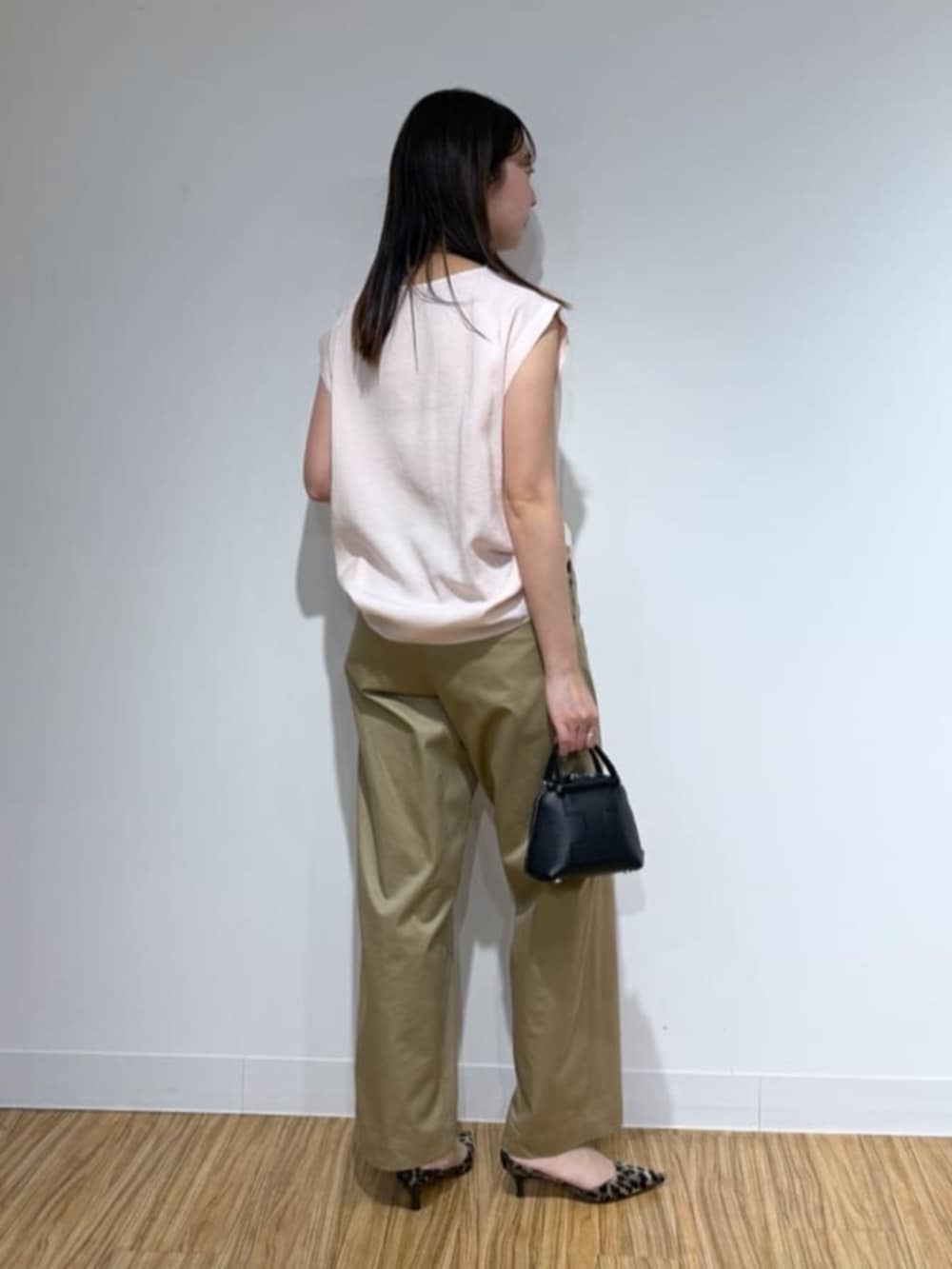 イエロー系のパンプス、ピンク系のシャツ/ブラウス、ベージュ系のチノパンツを着用したレディースの春コーディネートの2枚目の写真