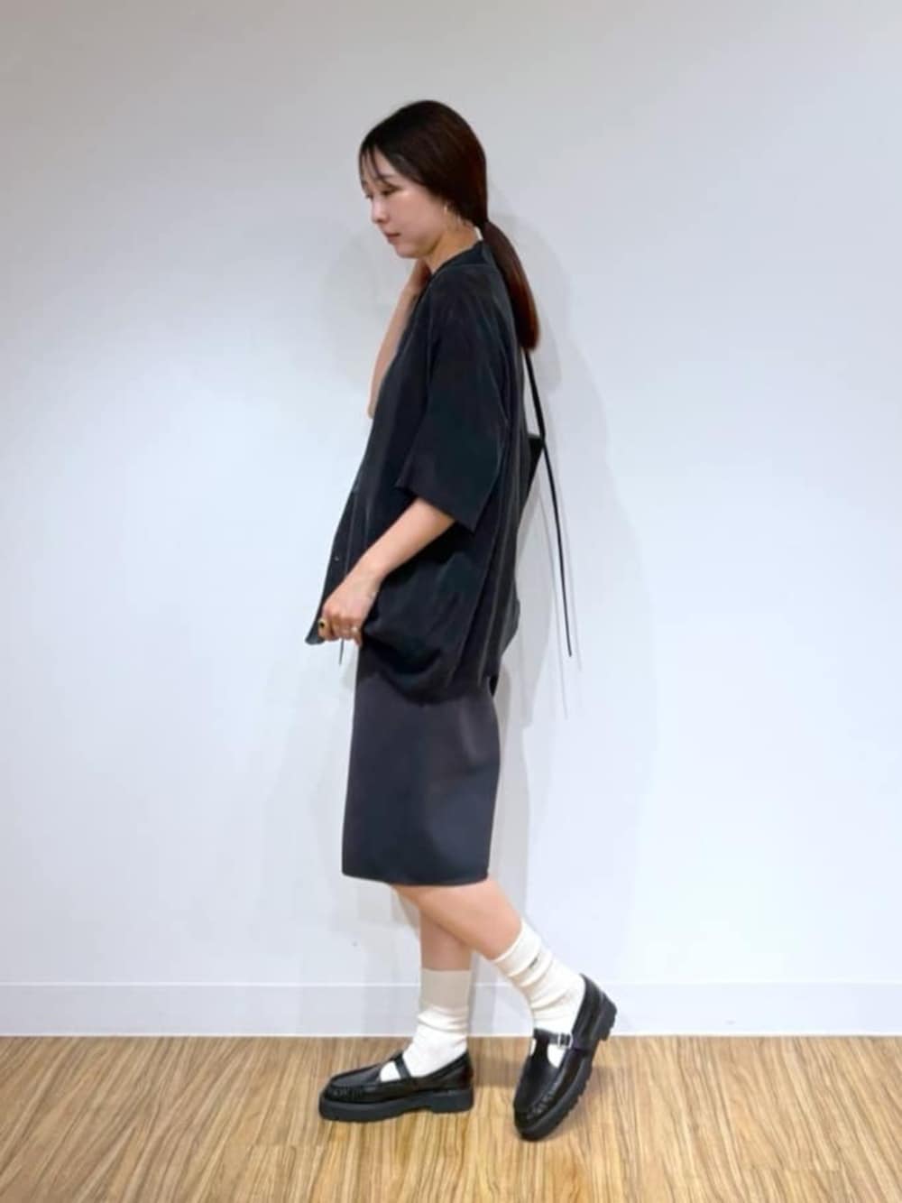 ブラック系のショルダーバッグ、ブラック系のローファー、グレー系のその他パンツを着用したレディースの夏コーディネートの2枚目の写真