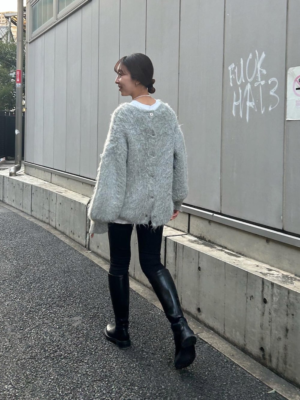 グレー系のニット/セーター、ブラック系のショルダーバッグを着用したレディースの秋コーディネートの2枚目の写真