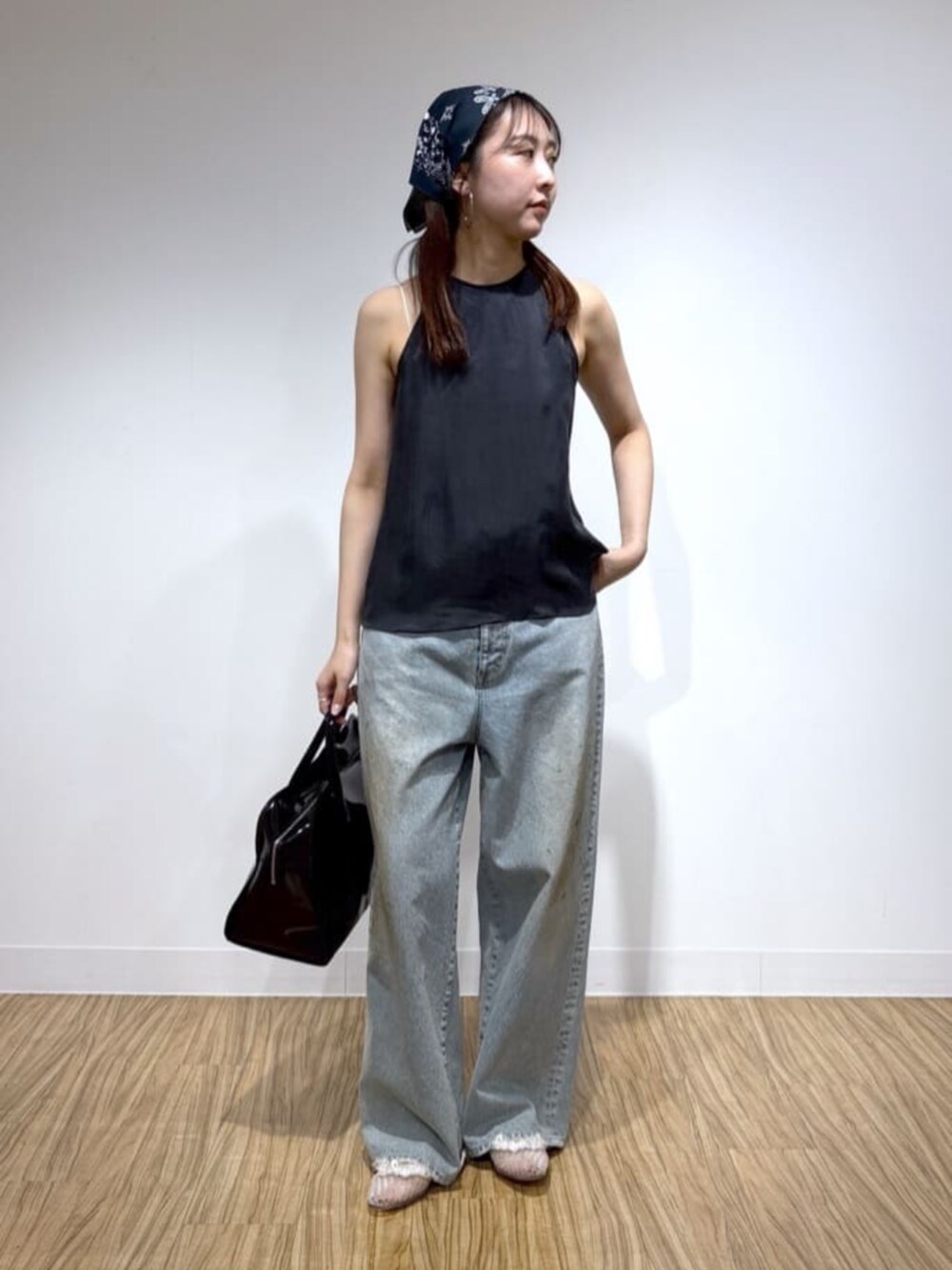 ブルー系のデニムパンツ、ブラック系のシャツ/ブラウス、ブラック系のボストンバッグを着用したレディースの夏コーディネートの2枚目の写真