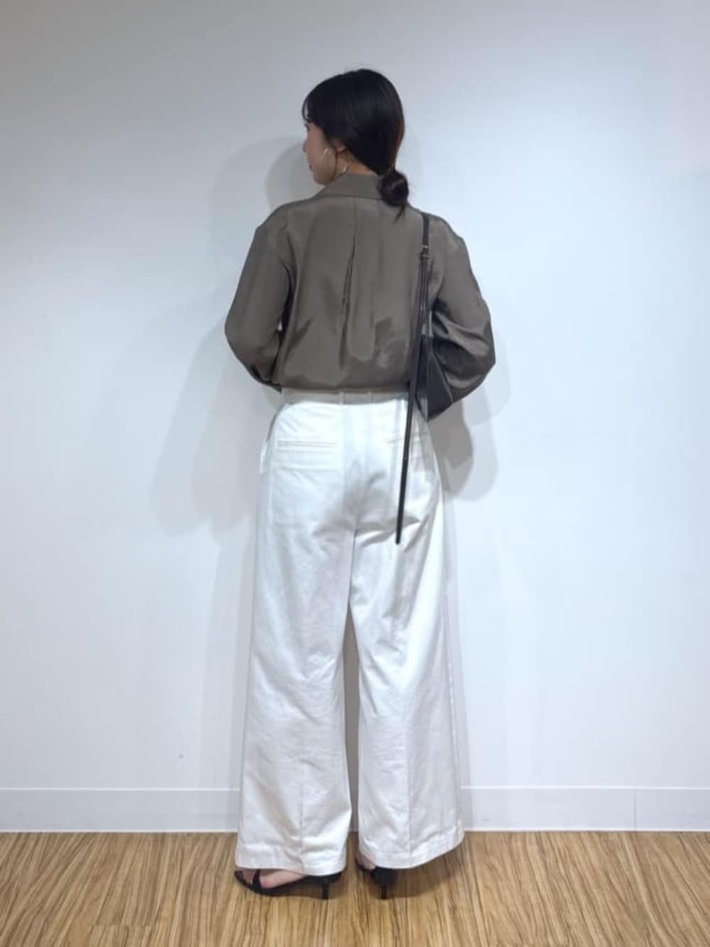 ブラウン系のショルダーバッグ、ブラック系のサンダル、ホワイト系のその他パンツを着用したレディースの夏コーディネートの3枚目の写真
