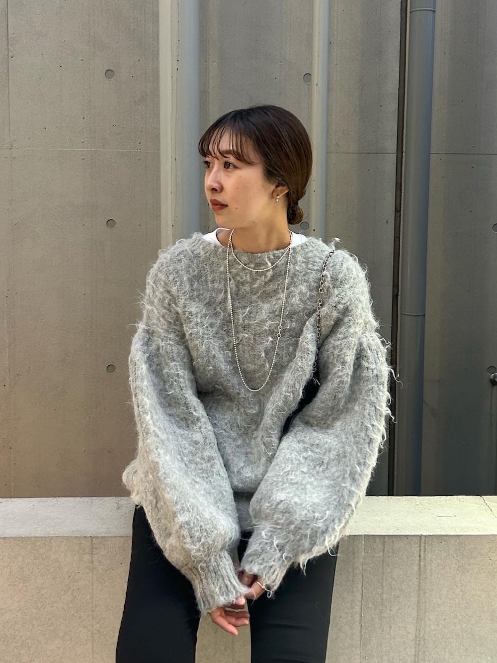 グレー系のニット/セーター、ブラック系のショルダーバッグを着用したレディースの秋コーディネートの3枚目の写真