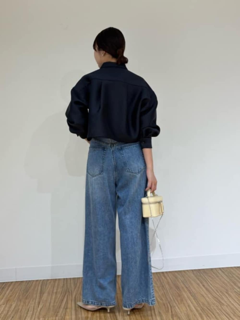 ベージュ系のショルダーバッグ、ブルー系のシャツ/ブラウス、ブルー系のデニムパンツを着用したレディースの秋コーディネートの3枚目の写真