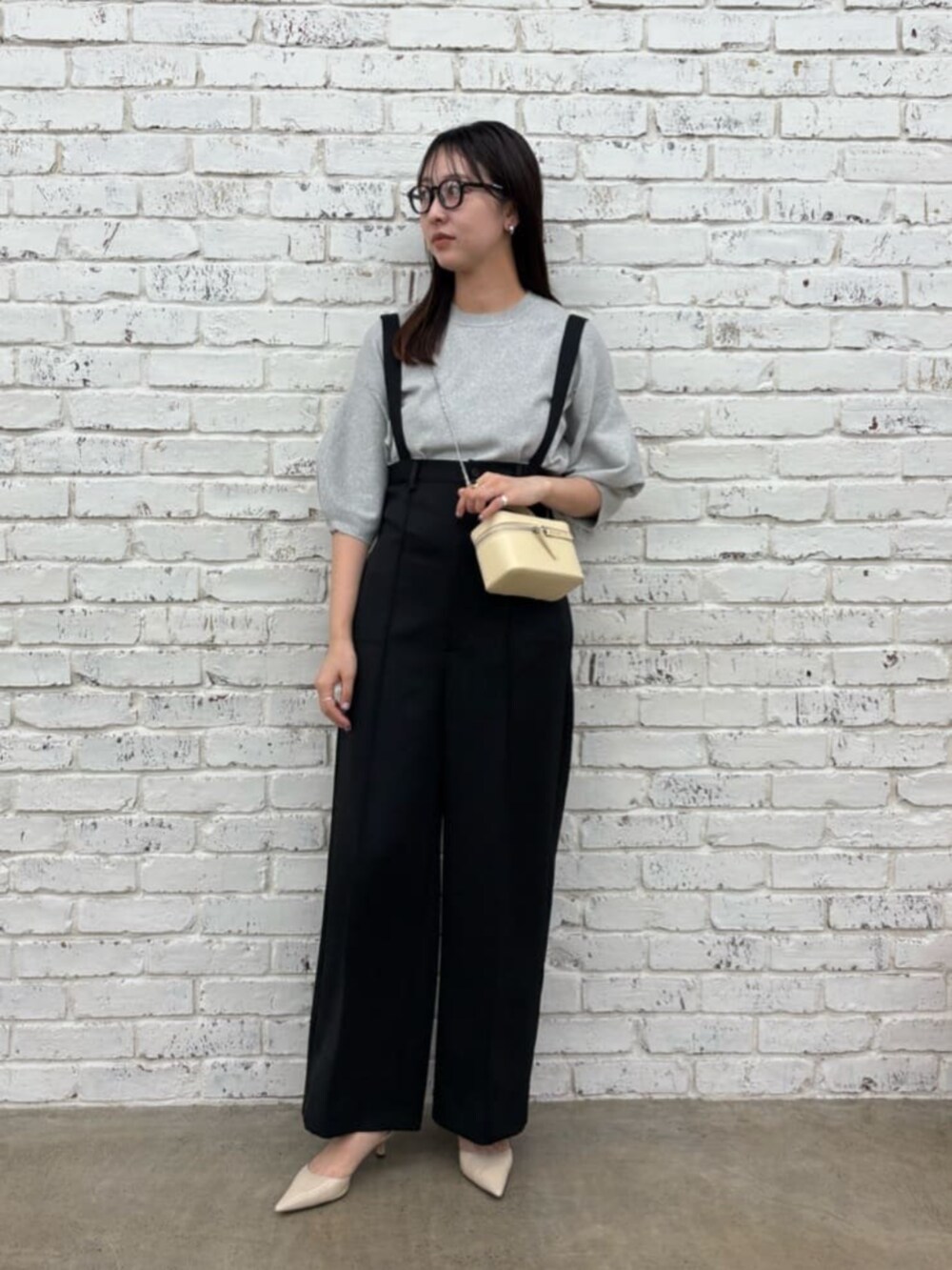 グレー系のニット/セーター、ブラック系のその他パンツ、ベージュ系のパンプスを着用したレディースの夏コーディネートの2枚目の写真