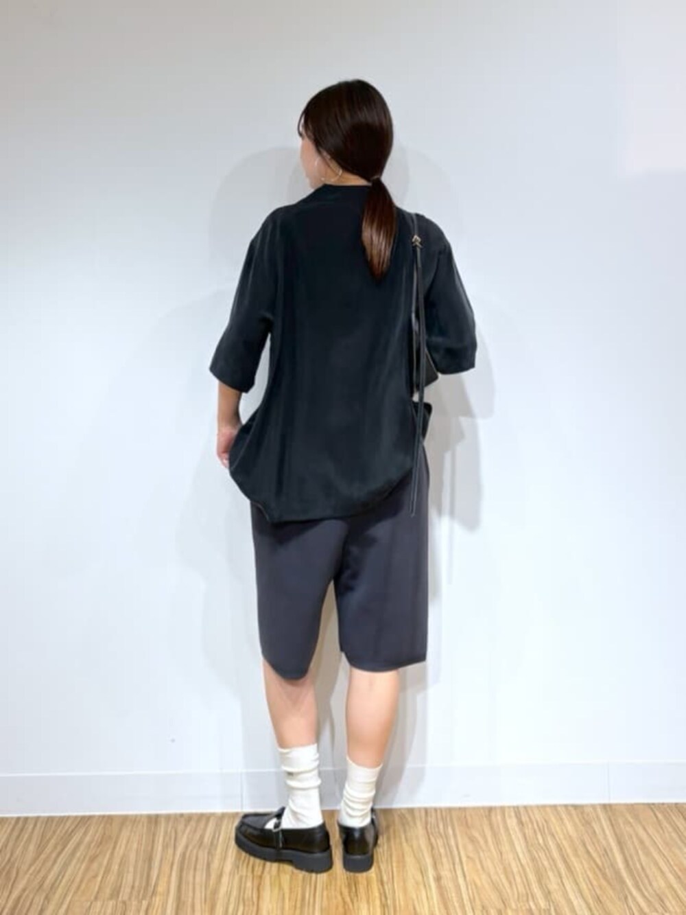 ブラック系のショルダーバッグ、ブラック系のローファー、グレー系のその他パンツを着用したレディースの夏コーディネートの3枚目の写真