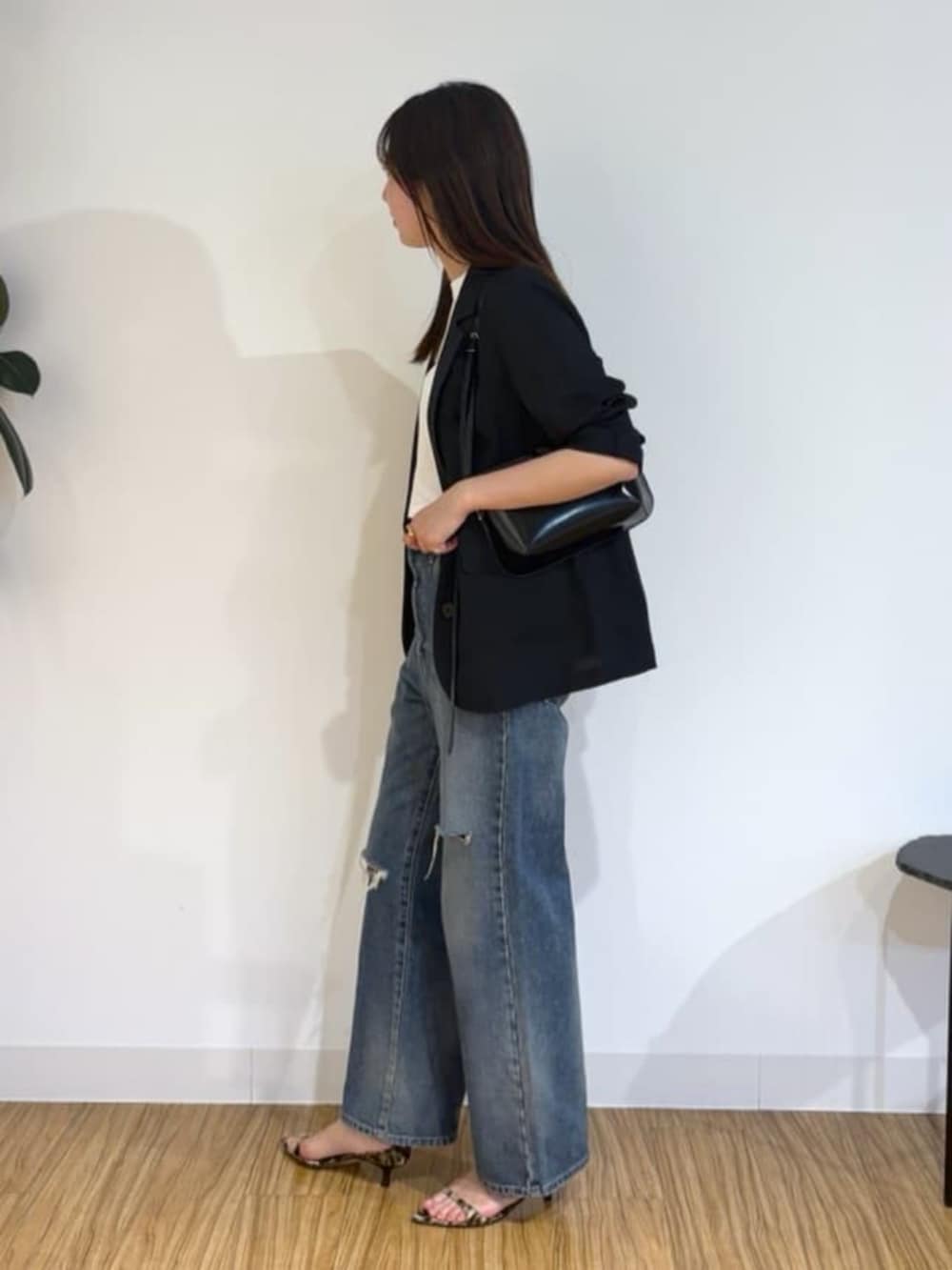 ブラック系のショルダーバッグ、イエロー系のサンダル、ブルー系のデニムパンツを着用したレディースの夏コーディネートの2枚目の写真