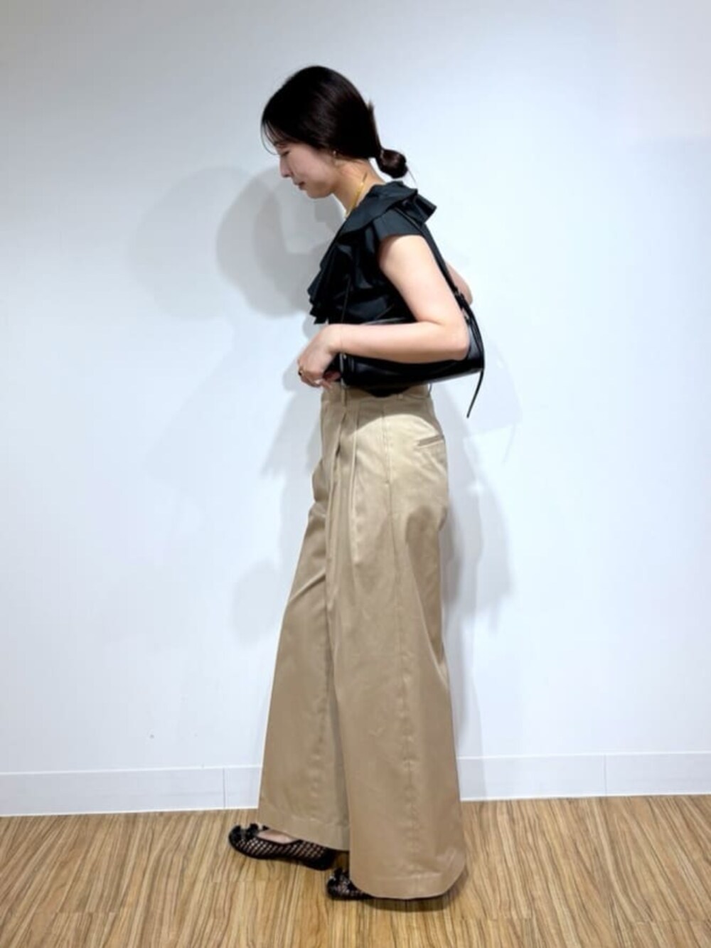 ベージュ系のその他パンツ、ブラック系のシャツ/ブラウス、ブラック系のショルダーバッグを着用したレディースの夏コーディネートの2枚目の写真
