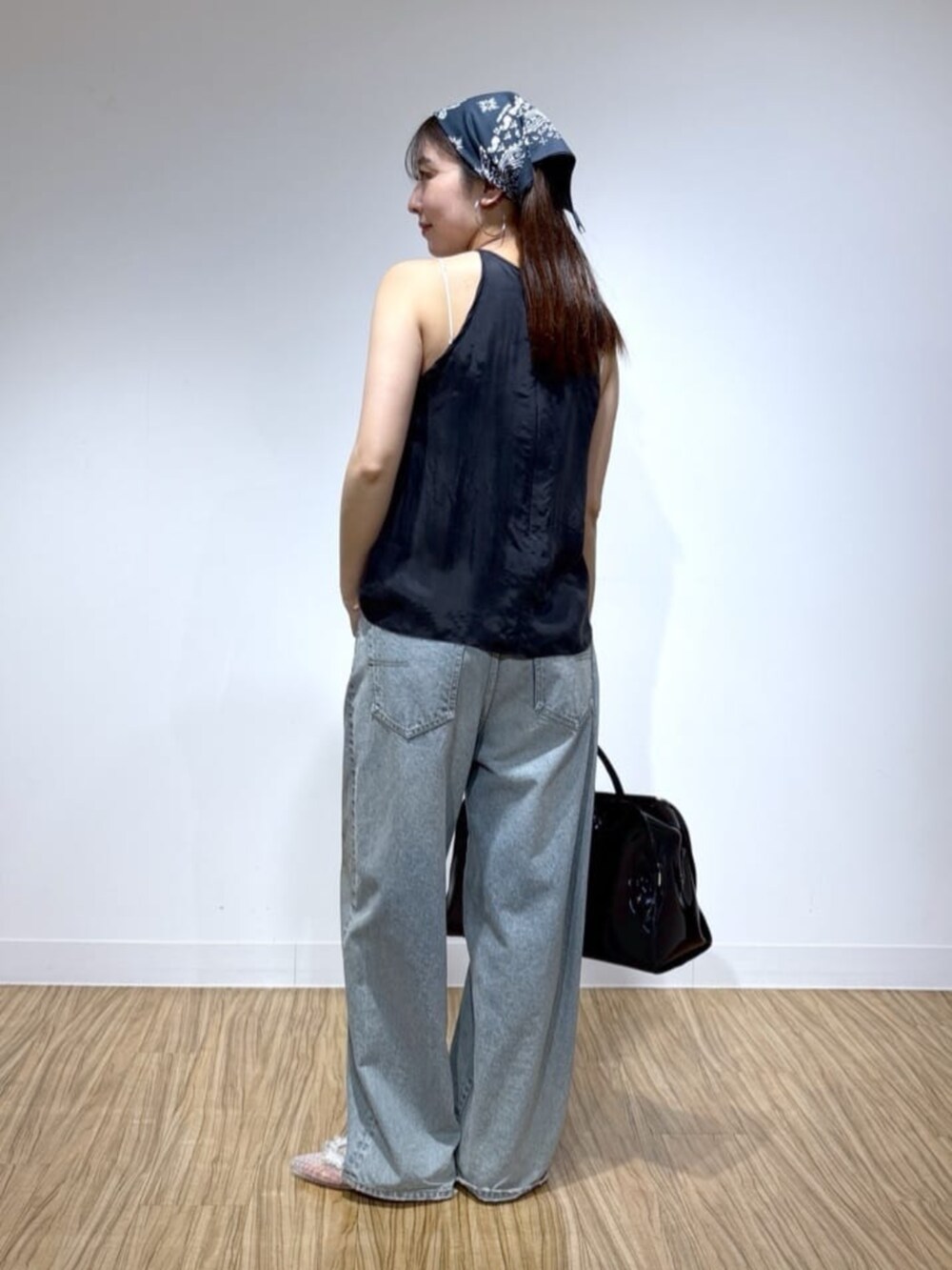 ブルー系のデニムパンツ、ブラック系のシャツ/ブラウス、ブラック系のボストンバッグを着用したレディースの夏コーディネートの3枚目の写真
