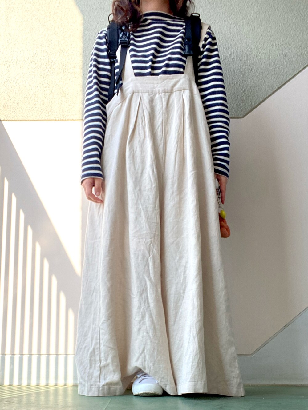 ベージュ系のサロペット/オーバーオール、ブルー系のTシャツ/カットソー、ブラック系のバックパック/リュックを着用したレディースの春コーディネートの2枚目の写真