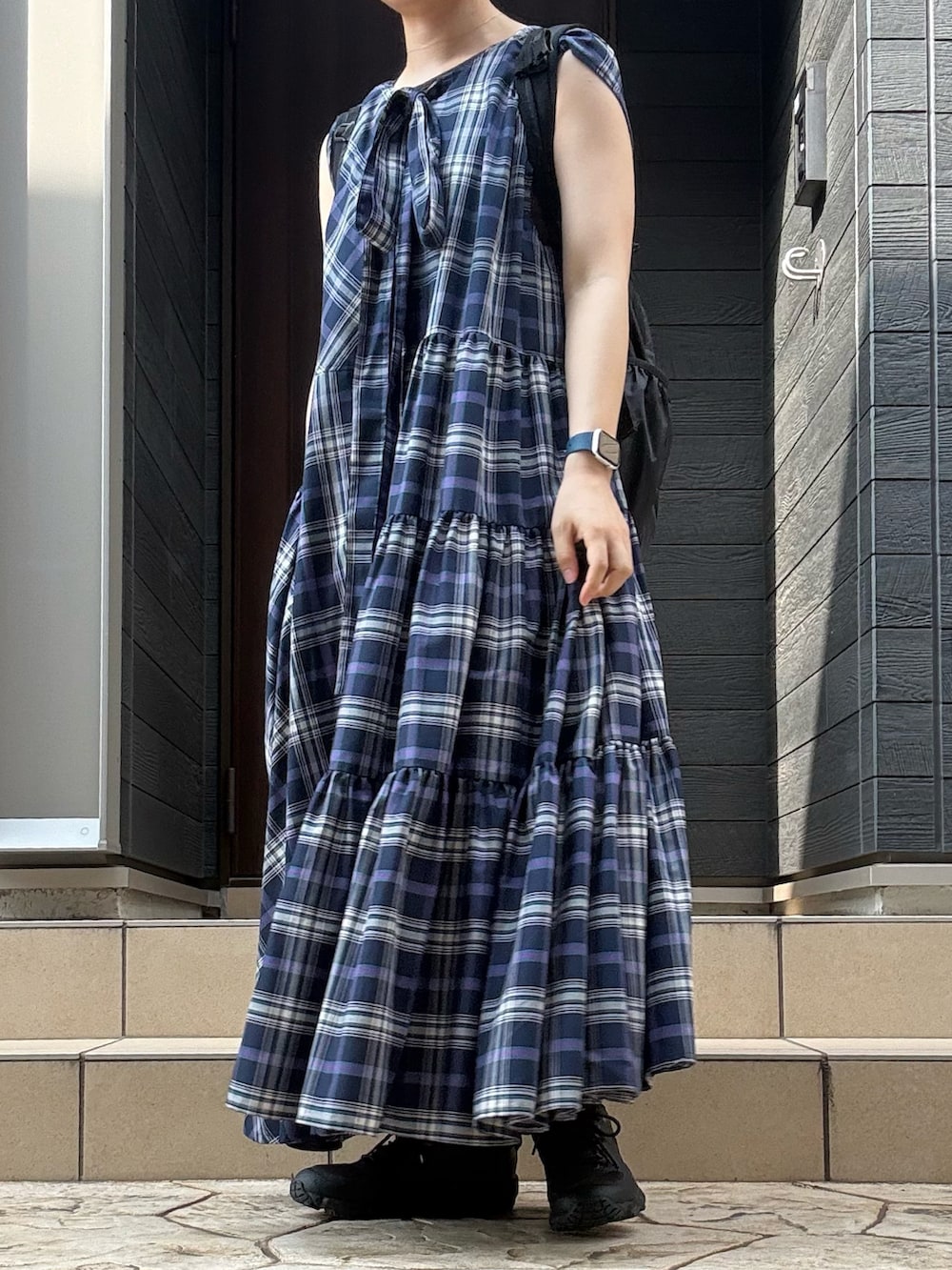 ブルー系のワンピース/ドレス、ブラック系のバックパック/リュック、グレー系のスニーカーを着用したレディースの夏コーディネートの2枚目の写真