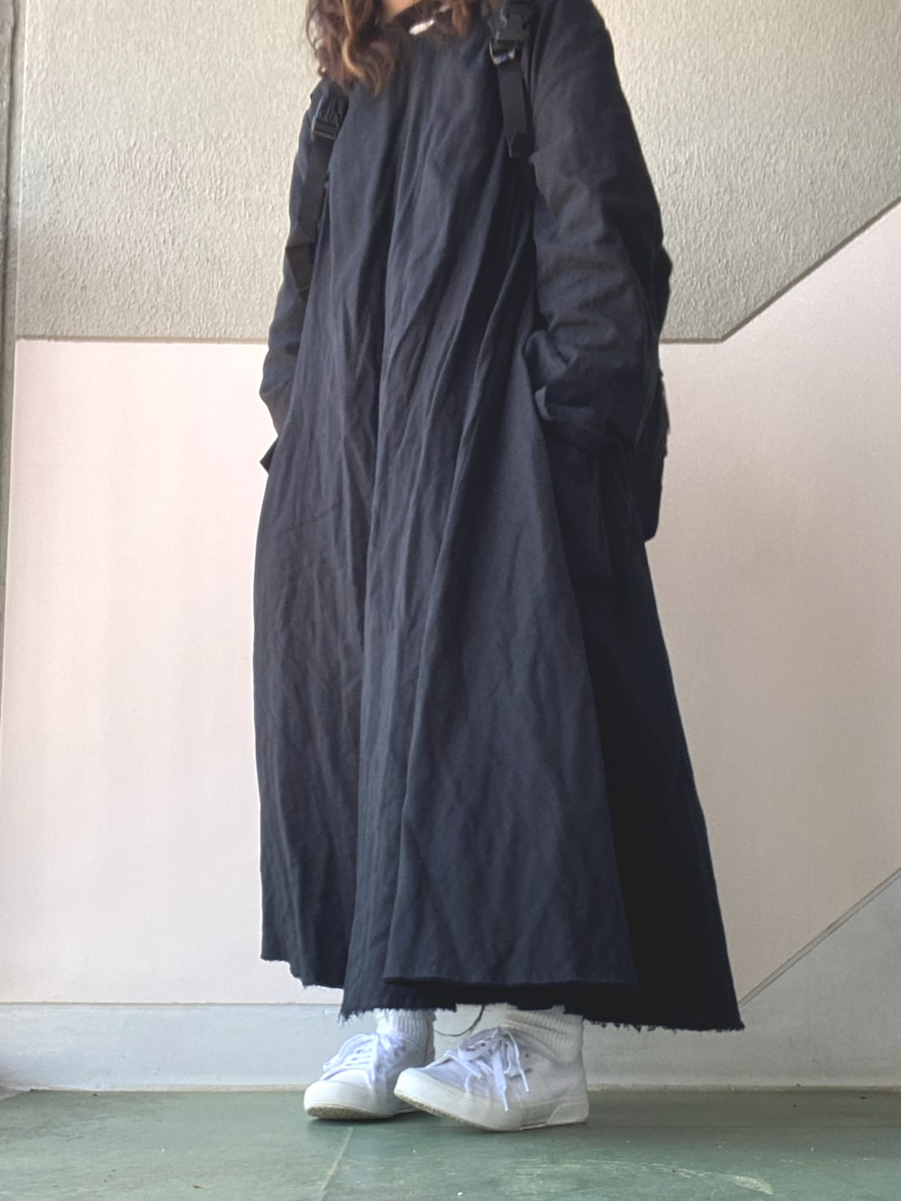 ブラック系のワンピース/ドレス、ホワイト系のスニーカー、ブラック系のバックパック/リュックを着用したレディースの春コーディネートの2枚目の写真