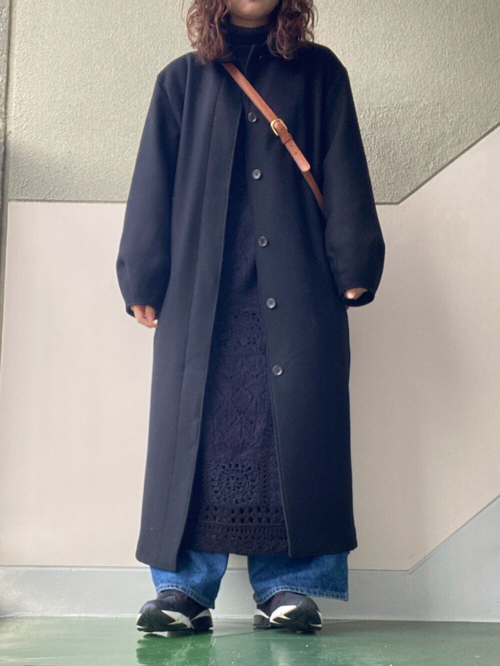 ブラック系のジャケット/アウター、ブラック系のワンピース、ブルー系のデニムパンツを着用したレディースの冬コーディネートの2枚目の写真