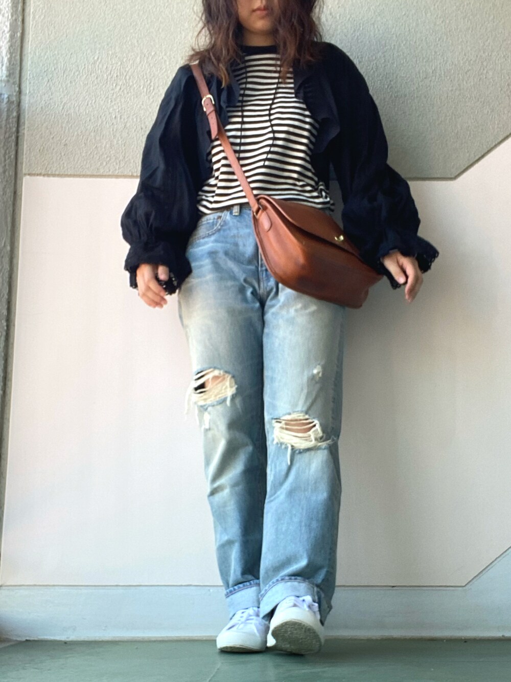 ブラック系のシャツ/ブラウス、ブラック系のトップス、ブルー系のデニムパンツを着用したレディースの春コーディネートの3枚目の写真