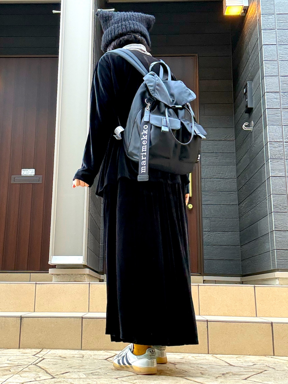 ホワイト系のスニーカー、ブラック系のシャツ/ブラウス、ブラック系のバックパック/リュックを着用したレディースの冬コーディネートの2枚目の写真