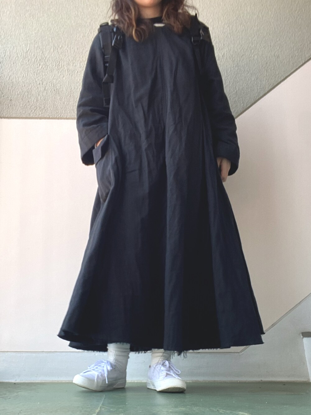 ブラック系のワンピース/ドレス、ホワイト系のスニーカー、ブラック系のバックパック/リュックを着用したレディースの春コーディネートの3枚目の写真