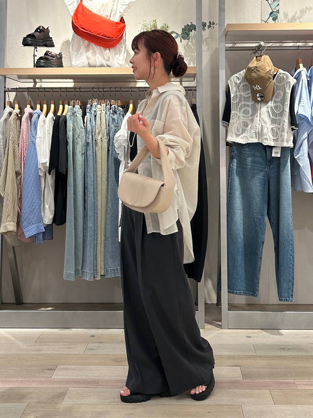 ベージュ系のハンドバッグ、ブラック系のサンダル、ホワイト系のシャツ/ブラウスを着用したレディースの夏コーディネートの2枚目の写真