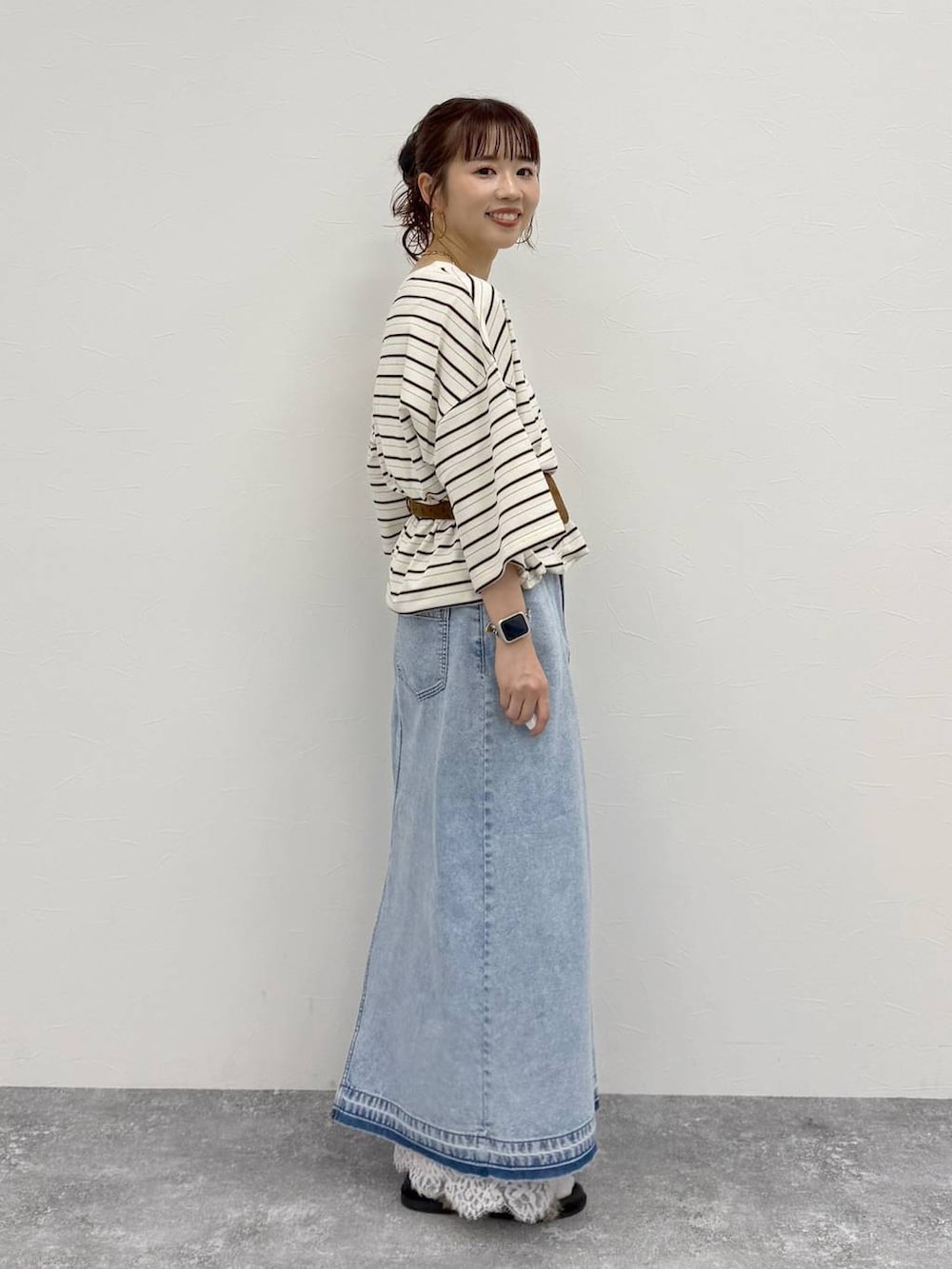 ブルー系のデニムスカート、ホワイト系のTシャツ/カットソー、イエロー系のベルトを着用したレディースの夏コーディネートの2枚目の写真