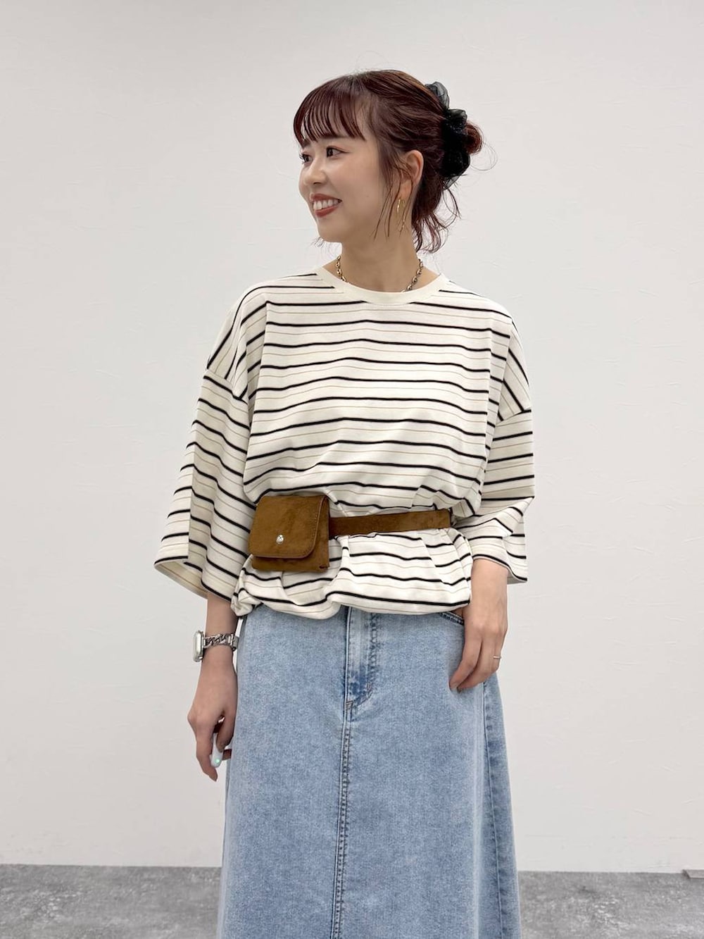 ブルー系のデニムスカート、ホワイト系のTシャツ/カットソー、イエロー系のベルトを着用したレディースの夏コーディネートの4枚目の写真