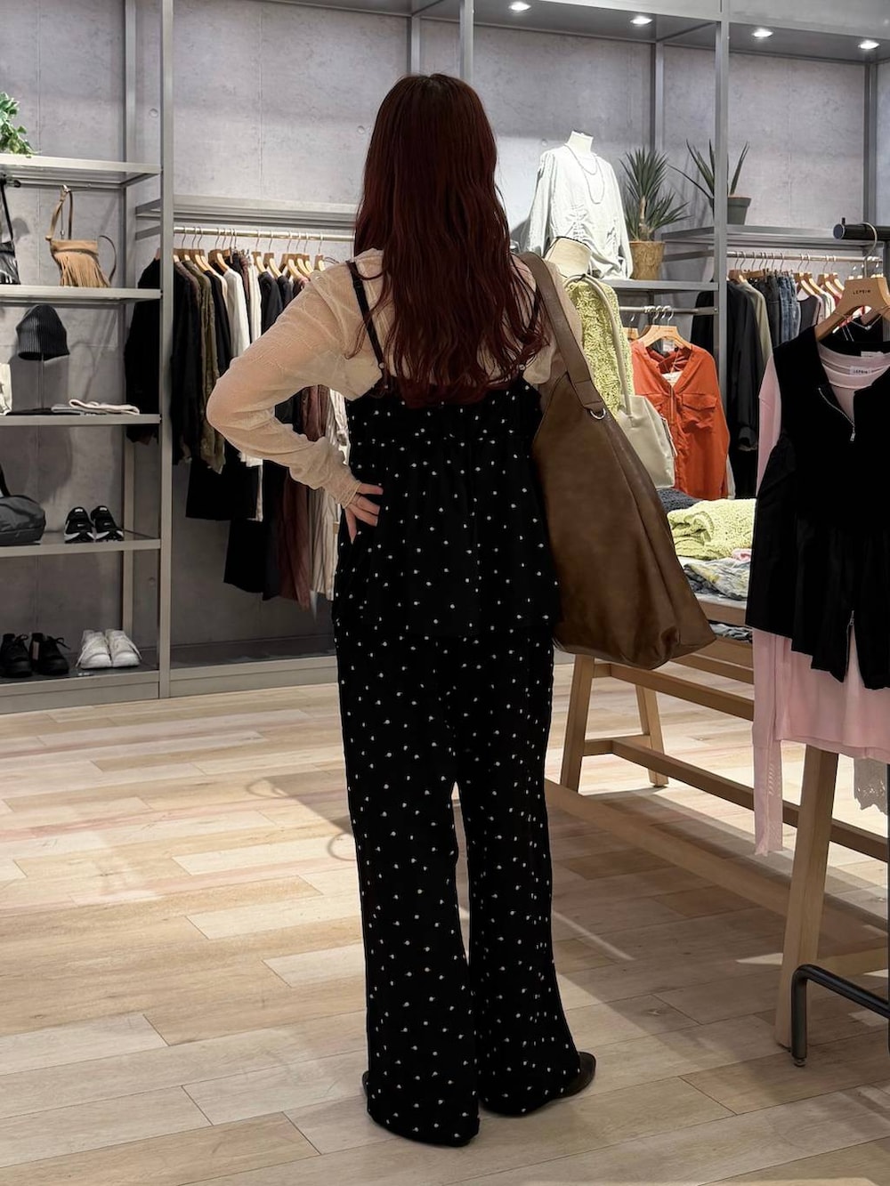 ブラウン系のショルダーバッグ、ブラック系のパンプス、ブラック系のサロペット/オーバーオールを着用したレディースの春コーディネートの2枚目の写真