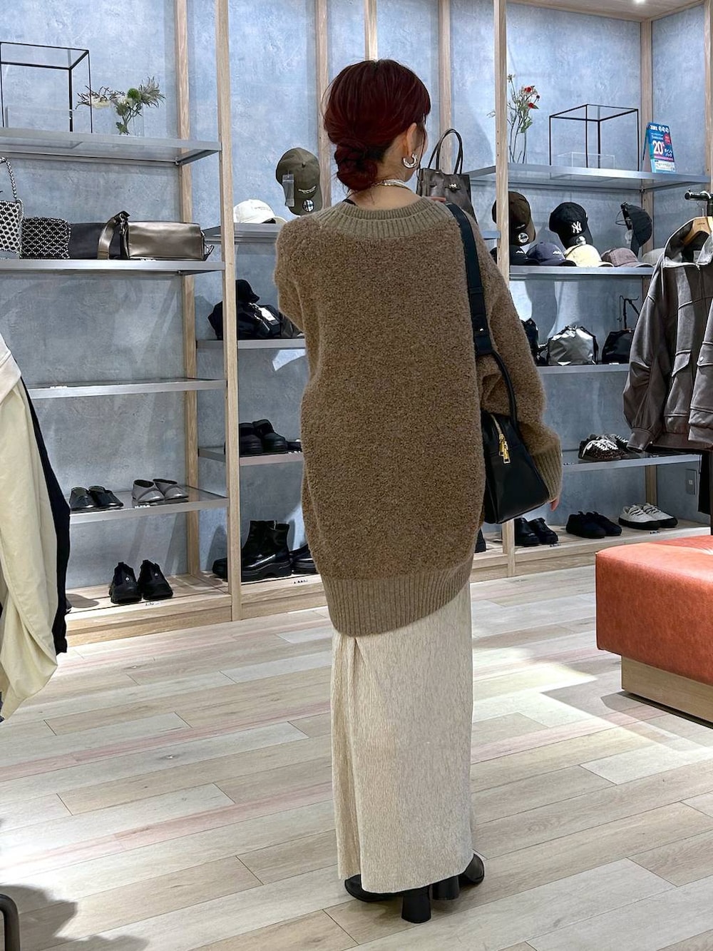 ブラウン系のカーディガン/ボレロ、ブラック系のブーツ、ブラック系のショルダーバッグを着用したレディースの秋コーディネートの3枚目の写真