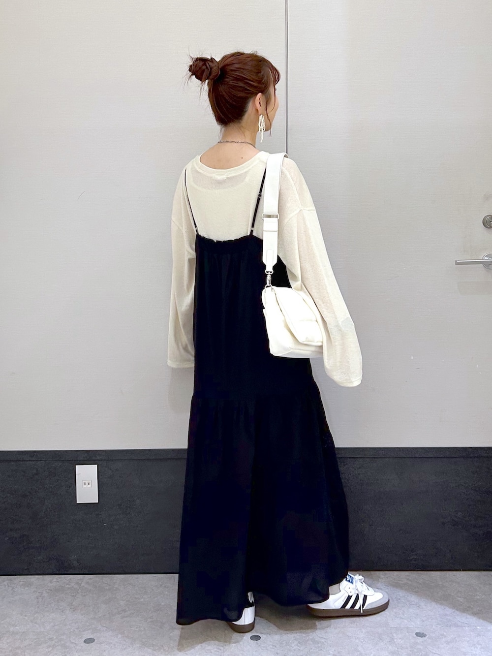 ブラック系のワンピース、イエロー系のTシャツ/カットソー、ホワイト系のショルダーバッグを着用したレディースの春コーディネートの3枚目の写真