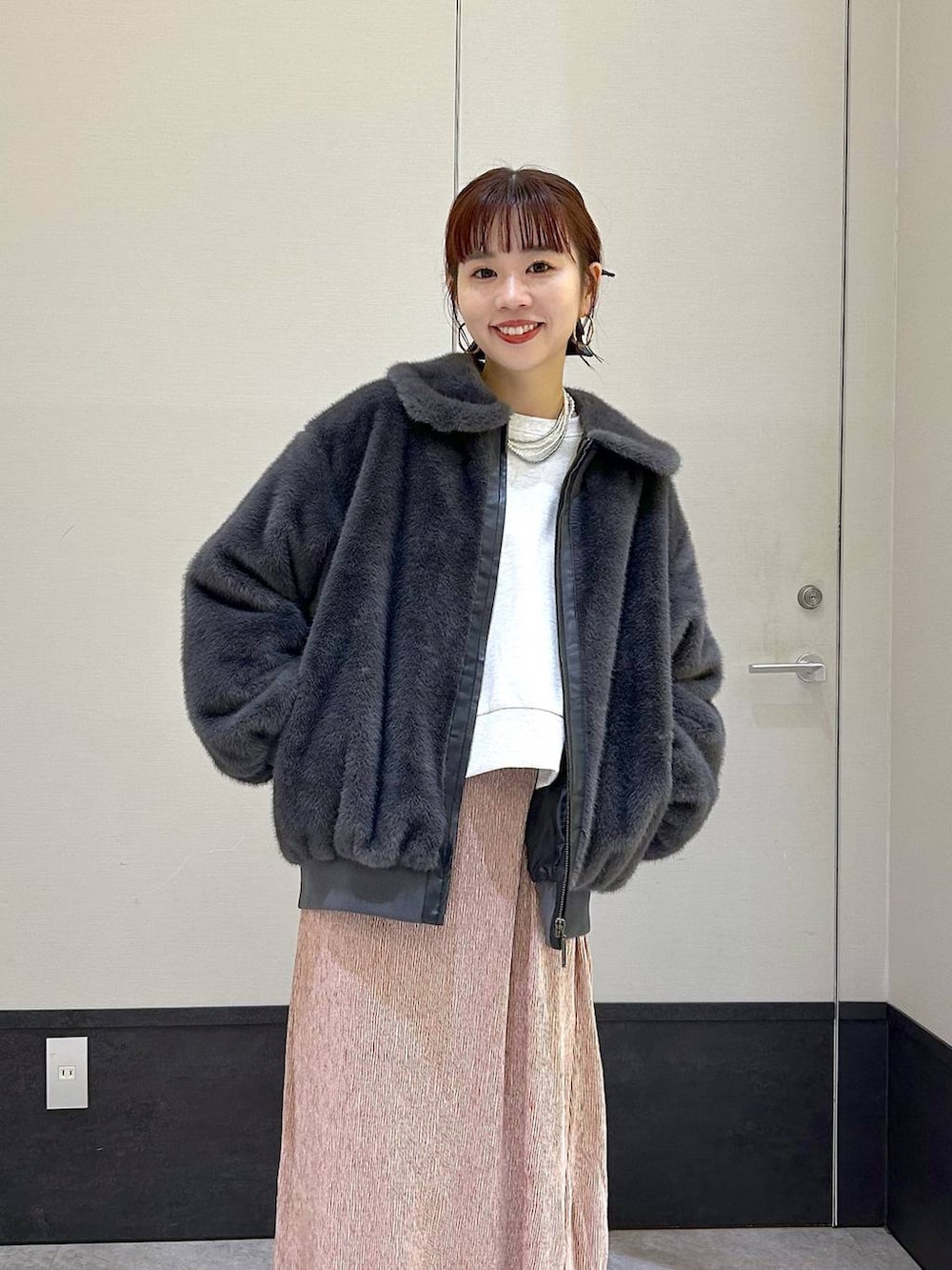 グレー系のブルゾン、グレー系のTシャツ/カットソー、ブラック系のブーツを着用したレディースの秋コーディネートの3枚目の写真