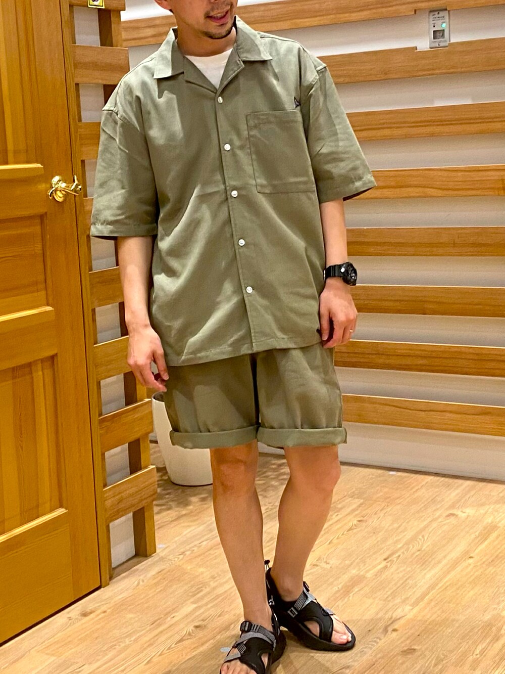 グリーン系のシャツ/ブラウス、ブラック系のサンダルを着用したメンズの夏コーディネートの2枚目の写真