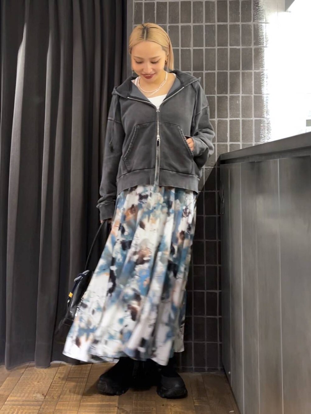 ブラック系のパーカー、ブラック系のボストンバッグ、ブラック系のブーツを着用したレディースの夏コーディネートの5枚目の写真