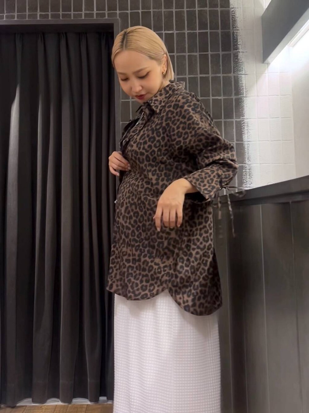 ホワイト系のスカート、ブラック系のローファー、ブラック系のタンクトップを着用したレディースの夏コーディネートの5枚目の写真