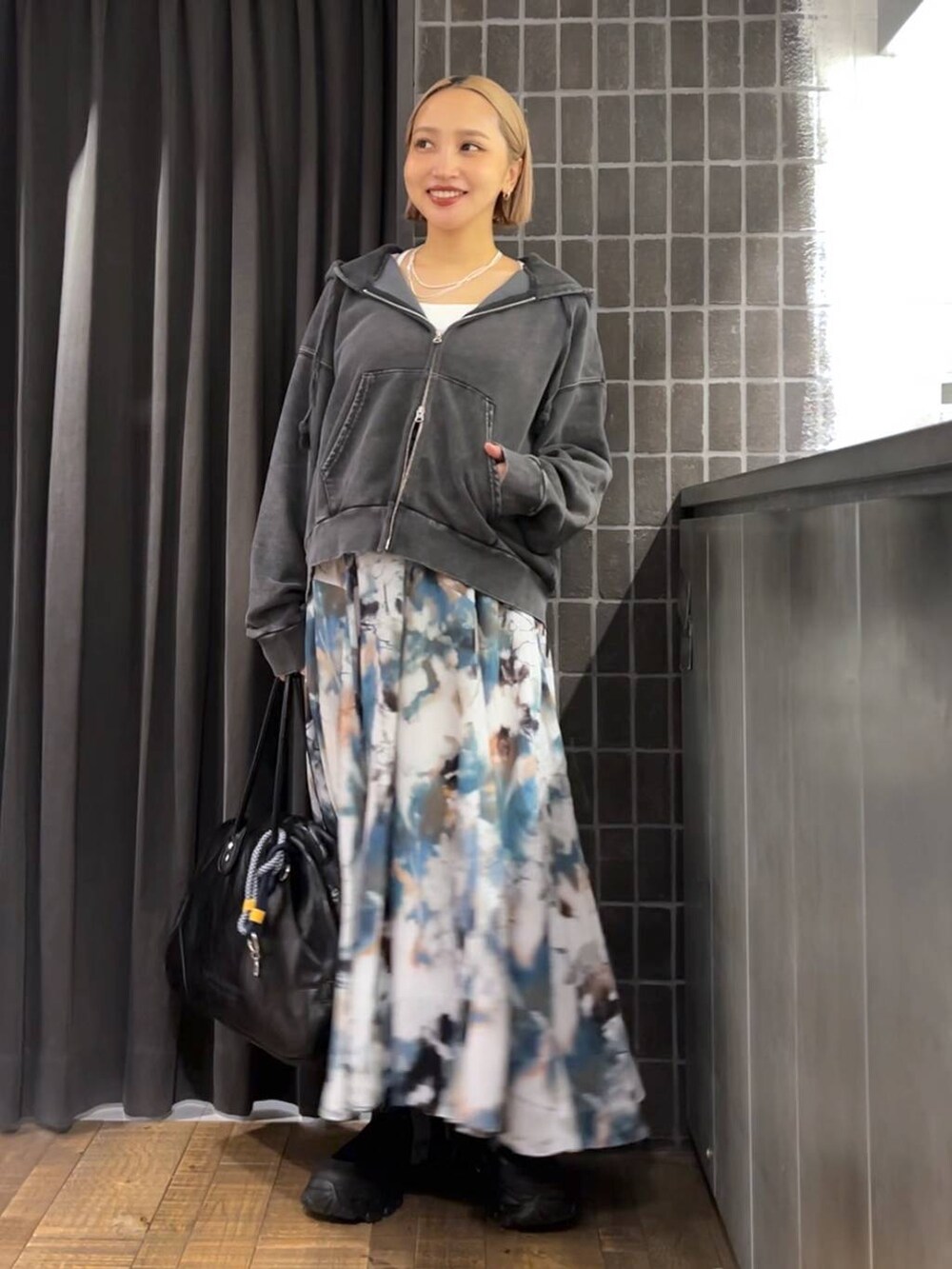 ブラック系のパーカー、ブラック系のボストンバッグ、ブラック系のブーツを着用したレディースの夏コーディネートの6枚目の写真