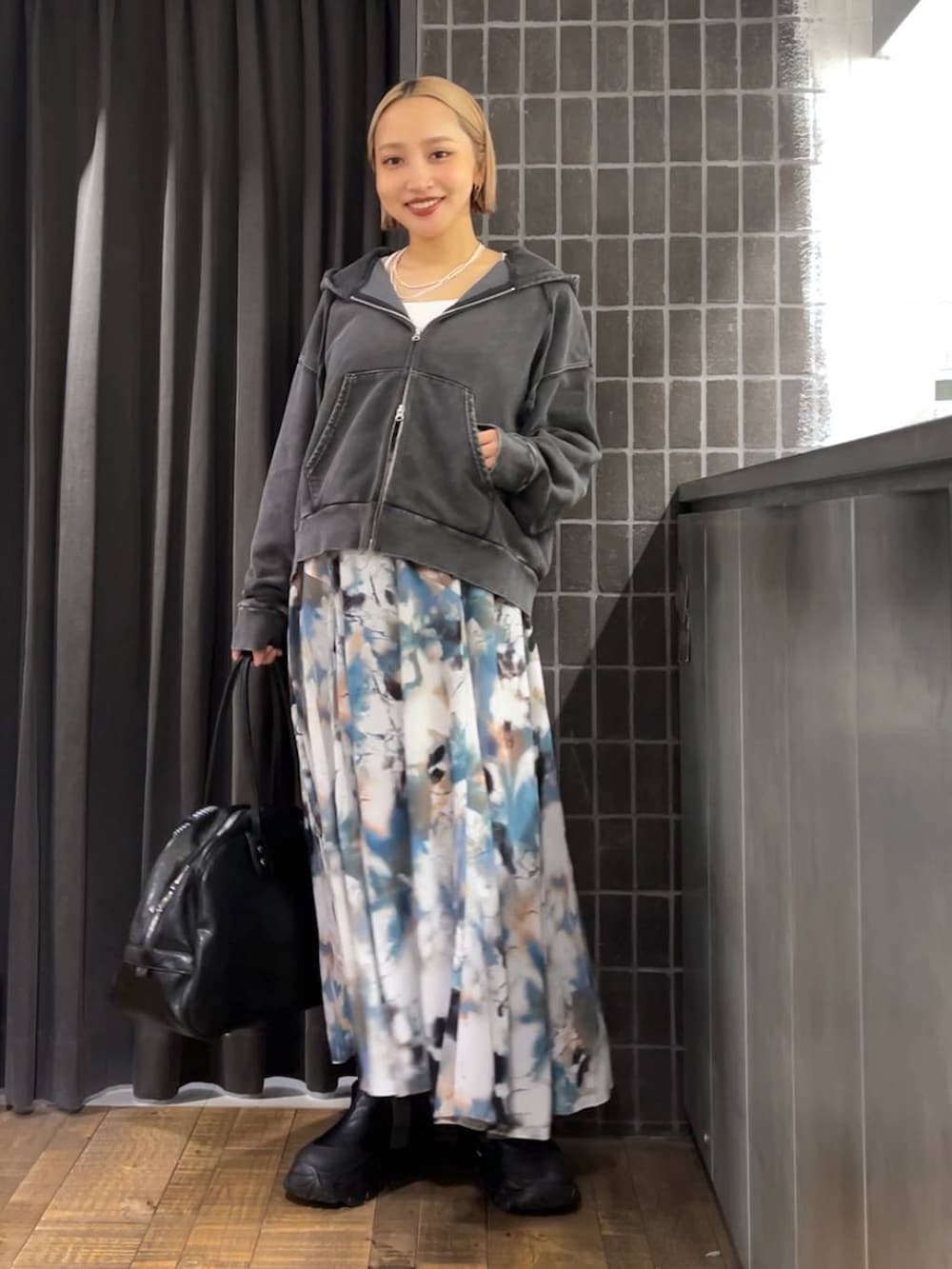 ブラック系のパーカー、ブラック系のボストンバッグ、ブラック系のブーツを着用したレディースの夏コーディネートの2枚目の写真