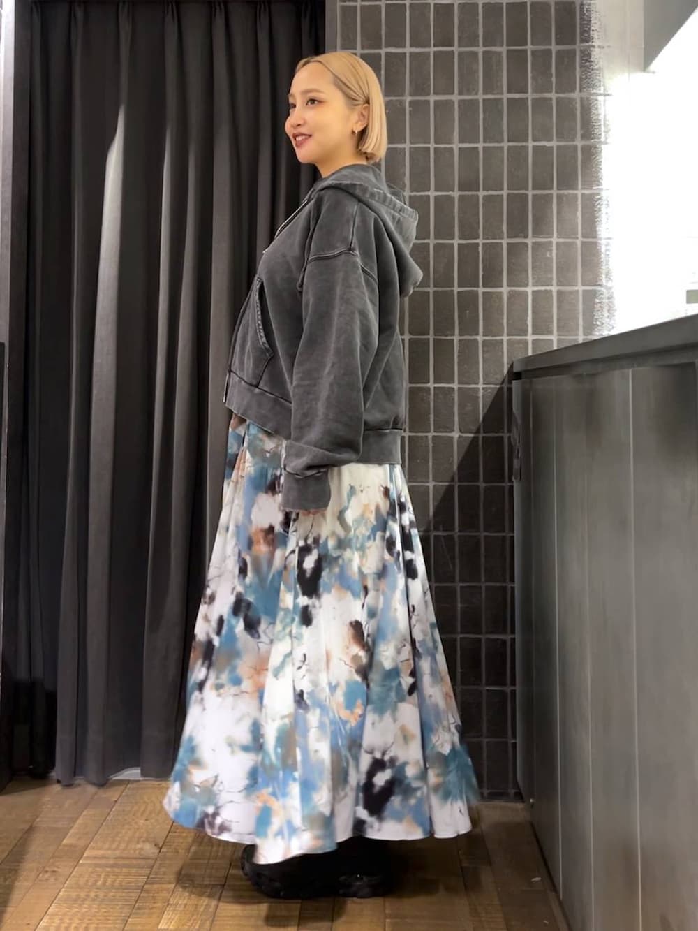 ブラック系のパーカー、ブラック系のボストンバッグ、ブラック系のブーツを着用したレディースの夏コーディネートの3枚目の写真