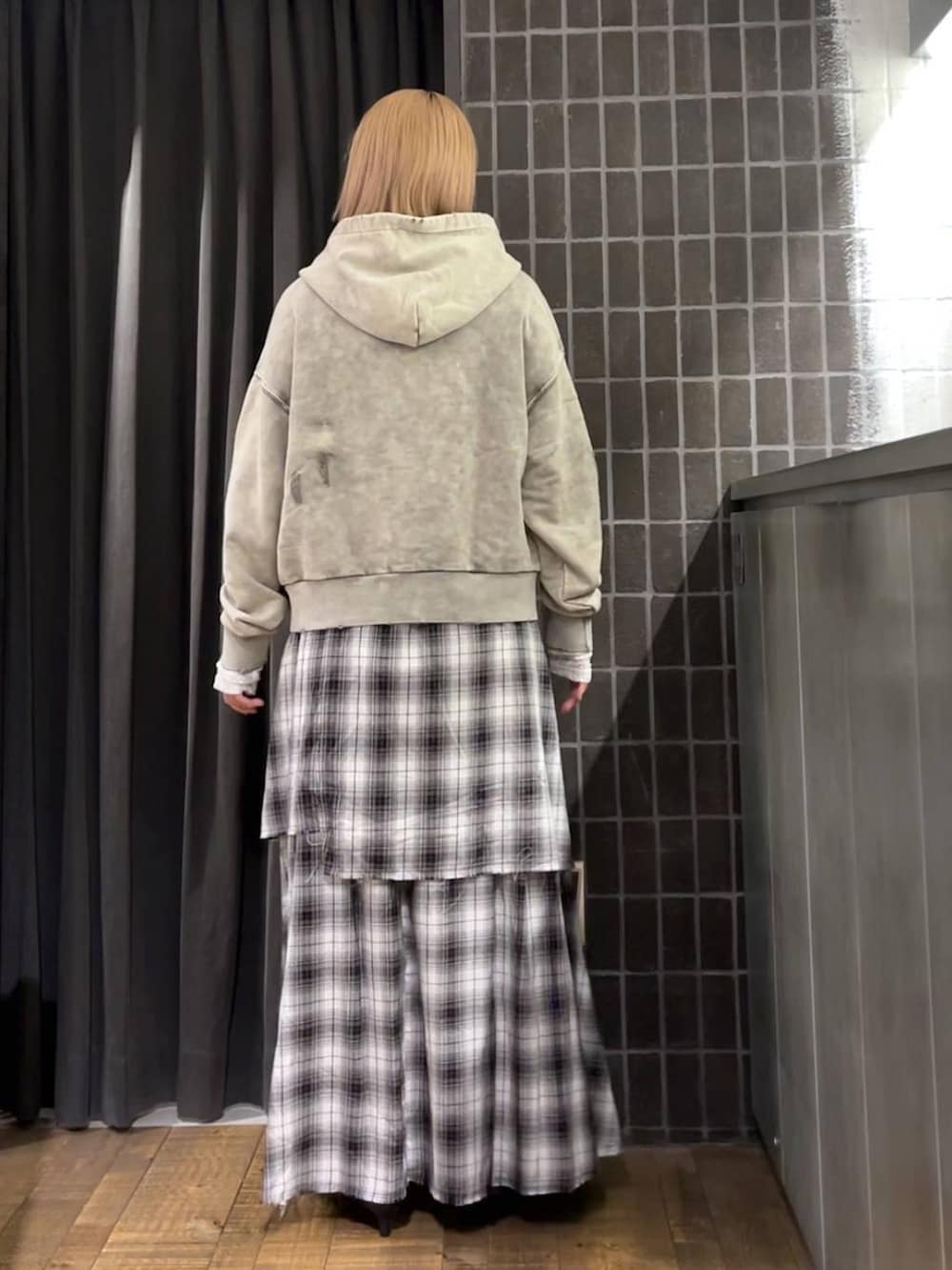 グレー系のパーカー、ブラック系のスカート、ブラック系のパンプスを着用したレディースの夏コーディネートの4枚目の写真