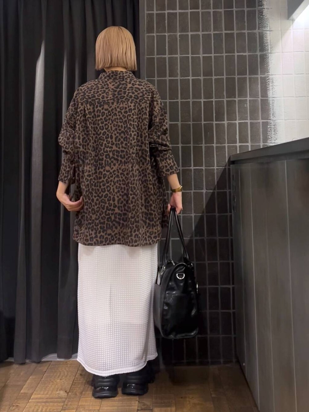 ホワイト系のスカート、ブラック系のローファー、ブラック系のタンクトップを着用したレディースの夏コーディネートの4枚目の写真