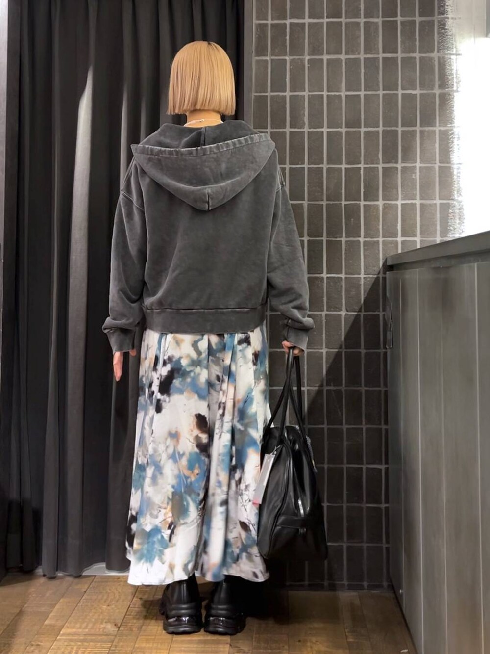 ブラック系のパーカー、ブラック系のボストンバッグ、ブラック系のブーツを着用したレディースの夏コーディネートの4枚目の写真