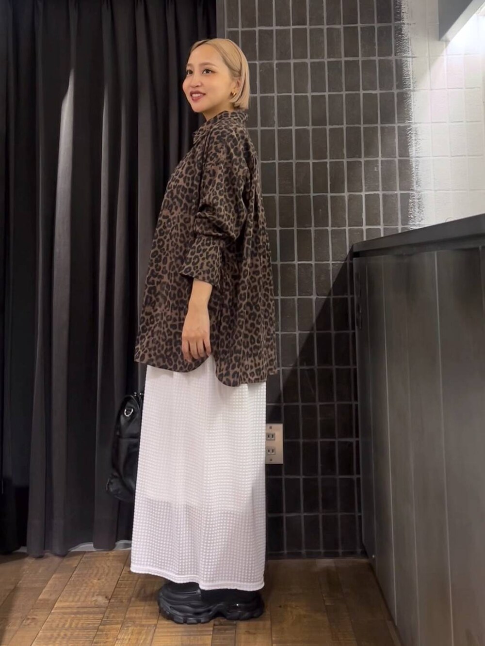 ホワイト系のスカート、ブラック系のローファー、ブラック系のタンクトップを着用したレディースの夏コーディネートの3枚目の写真