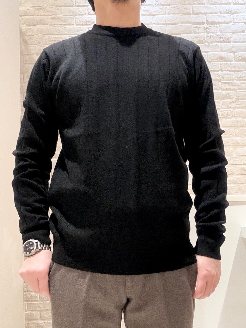 グレー系のテーラードジャケット、ブラック系のニット/セーター、グレー系のスラックスを着用したメンズの冬コーディネートの7枚目の写真
