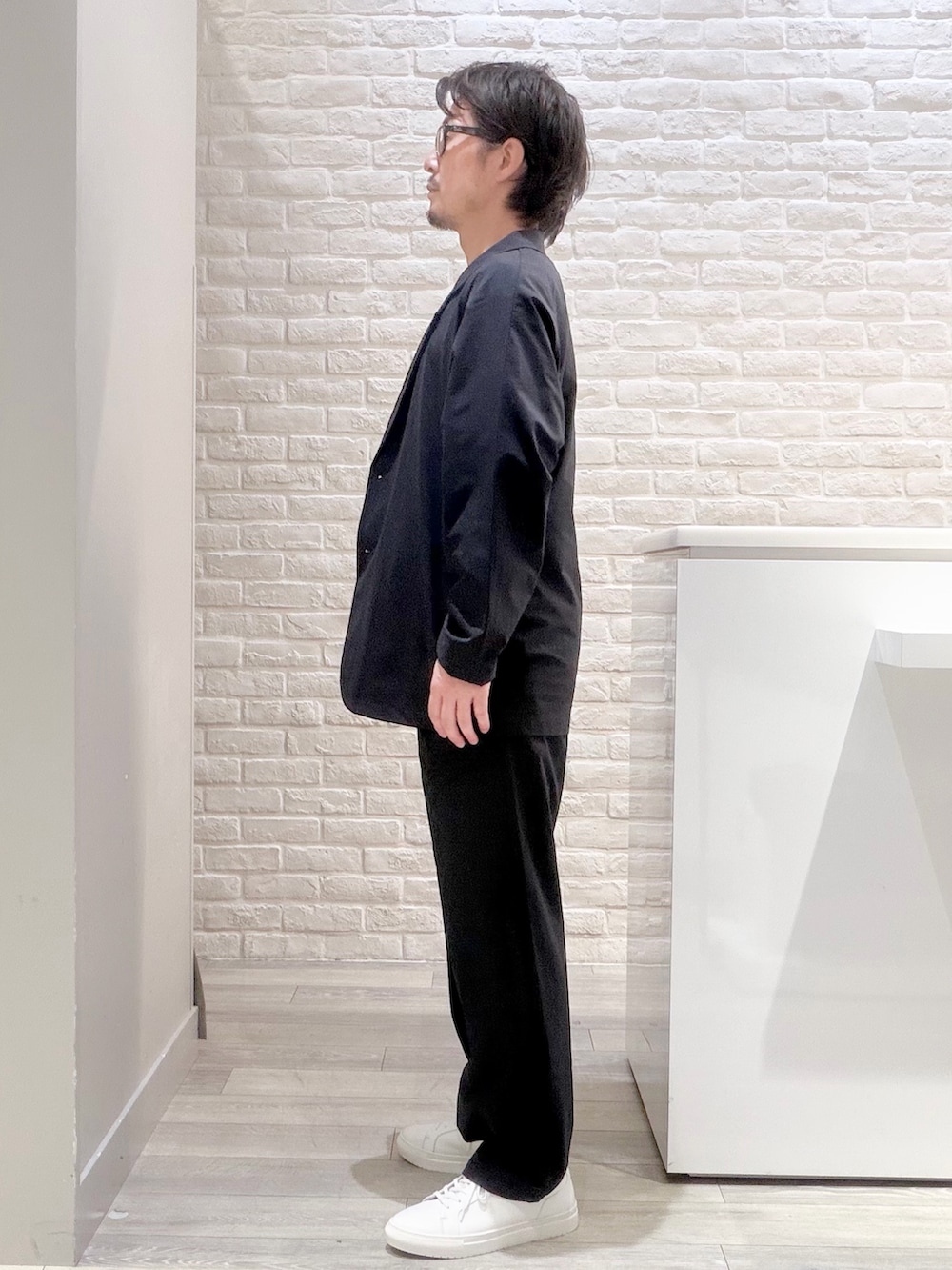 ブルー系のスラックス、ブルー系のセットアップ、ホワイト系のTシャツ/カットソーを着用したメンズの夏コーディネートの6枚目の写真